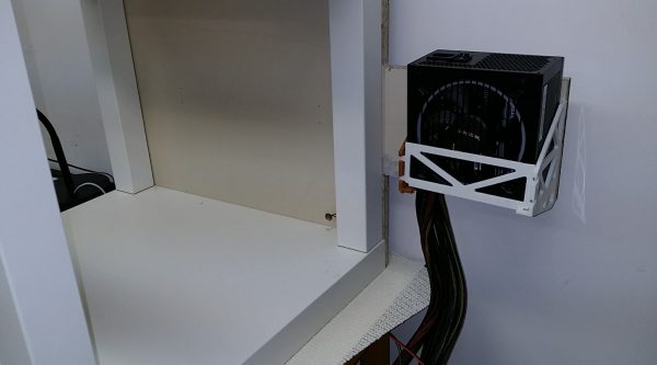 Power supply attached to back wall of enclosure